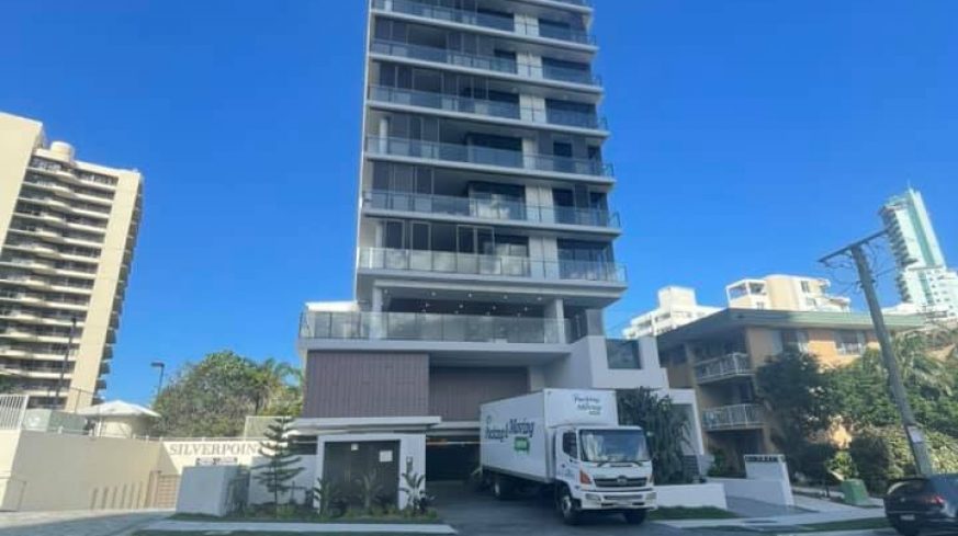removals Truck Parked by High Building — The Packing & Moving Company in Tanah Merah, QLD